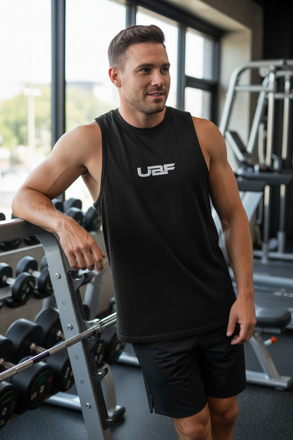 Man wearing a black sleeveless shirt with 'UBF' logo in a gym setting